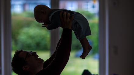 Ein Vater spielt mit seinem Baby (Symbolbild).