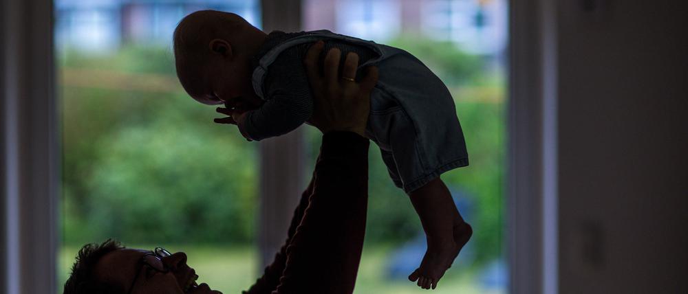 Ein Vater spielt mit seinem Baby (Symbolbild).