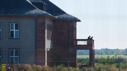 14.09.2023, Brandenburg, Schönefeld: Personen stehen auf der Terrasse des Generalshotels. Der Abriss des historischen Generalshotels auf dem Gelände des Flughafens BER soll am Donnerstag beginnen. Im Jahr 2011 wurde entschieden, das Gebäude abzureißen, weil in dem Bereich ein neues Regierungsterminal entstehen sollte. Seit langem gibt es Widerstand gegen die Pläne. Foto: Annette Riedl/dpa +++ dpa-Bildfunk +++