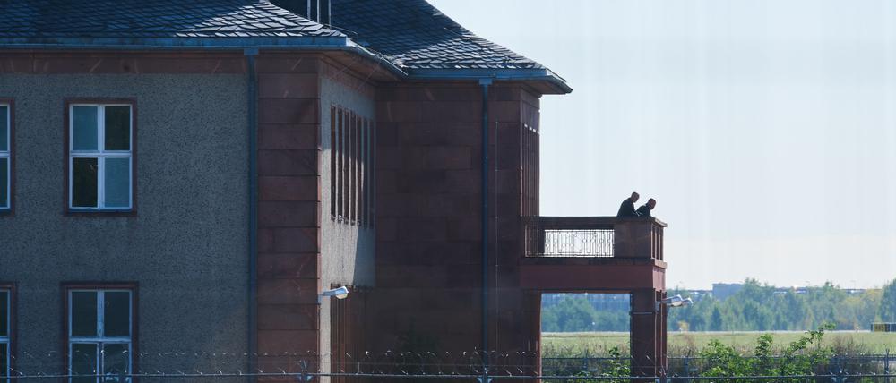 14.09.2023, Brandenburg, Schönefeld: Personen stehen auf der Terrasse des Generalshotels. Der Abriss des historischen Generalshotels auf dem Gelände des Flughafens BER soll am Donnerstag beginnen. Im Jahr 2011 wurde entschieden, das Gebäude abzureißen, weil in dem Bereich ein neues Regierungsterminal entstehen sollte. Seit langem gibt es Widerstand gegen die Pläne. Foto: Annette Riedl/dpa +++ dpa-Bildfunk +++