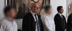 Zwei Angeklagte stehen mit ihren Anwälten Cem Kilic (2.v.l.) und Zubair Khan (r) im Gerichtssaal. 