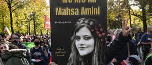 Ein Teilnehmer der Großdemonstration „Solidarität mit den Protestierenden im Iran“ hält in Berlin ein Plakat mit der Aufschrift „We Are All Mahsa Amini“.