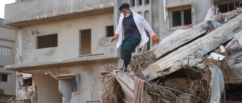 Ein Retter arbeitet an einem beschädigten Gebäude in Darna, Libyen. Nach Angaben des UN-Nothilfebüros (OCHA) kamen allein in der stark zerstörten Hafenstadt Darna rund 11.300 Menschen ums Leben.
