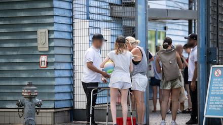 Besucher eines Sommerbades in Berlin-Neukölln werden am Eingang von Sicherheitspersonal kontrolliert. 