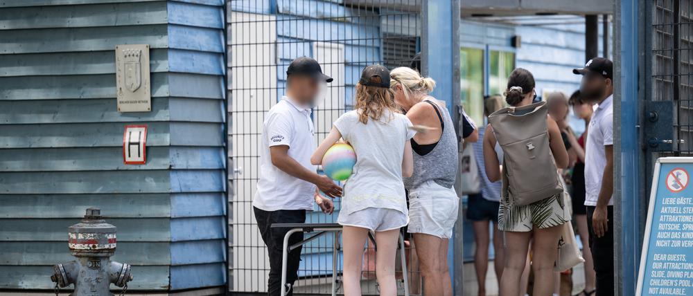 Besucher eines Sommerbades in Berlin-Neukölln werden am Eingang von Sicherheitspersonal kontrolliert. 