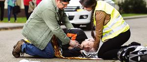 Nach einem Unfall legen Helfer den Betroffenen in die stabile Seitenlage, überprüfen die Atmung und beginnen gegebenenfalls mit einer Herzdruckmassage.