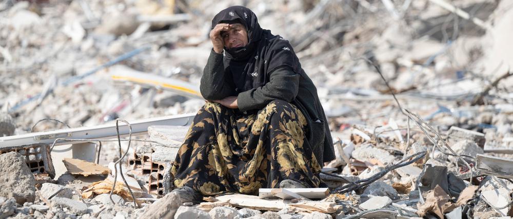 Eine Frau sitzt im türkischen Antalya zwischen Trümmern und beobachtet die Bergung von Opfern. Am 6. Februar 2023 bebte die Erde in der Türkei mit einer Stärke von knapp 8 von 10 Punkten auf der Richterskala.