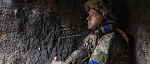 Ein ukrainischer Soldat isst in seiner Stellung in der Nähe der Frontlinie bei Bachmut ein Stück Brot.