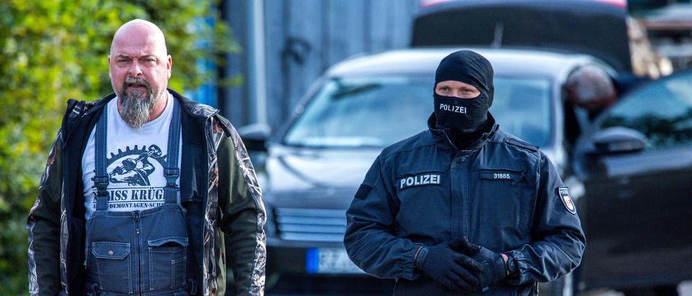  Sven Krüger (l.), bundesweit bekannter Rechtsextremist, wird bei einer Durchsuchungsaktion auf seinem Grundstück in Jamel von einem Polizeibeamten begleitet. 