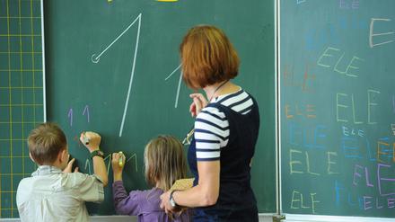 Ein rechtshändiger Junge und ein linkshändiges Mädchen der ersten Klasse einer Grundschule im Unterricht.