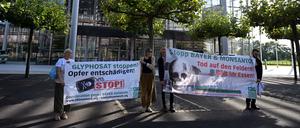 14.09.2023, Nordrhein-Westfalen, Leverkusen: Nicht alle sind für eine Verlängerung der Zulassung: vier Personen halten vor der Konzernzentrale von Baye Banner in den Händen. Die Aktion richtet sich gegen die Verlängerung der EU-Zulassung des Pestizids Glyphosat.