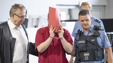Der Angeklagte (2.v.l.) wird von Justizwachtmeistern in den Verhandlungssaal gebracht. Die Staatsanwaltschaft wirft dem zum Tatzeitpunkt 30-Jährigen vor, die 14 Jahre alte Schülerin Ayleen aus dem südbadischen Gottenheim in Baden-Württemberg im Juli 2022 umgebracht zu haben. 