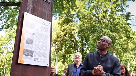 Joe Chialo (CDU), Berliner Kultursenator, betrachtet die neu eingeweihte Mahn- und Erinnerungsstele. Die Tafel zur Erinnerung an die deutsche Kolonialgeschichte steht am ehemaligen ·Afrika-Haus·, dem Sitz der früheren Deutschen Kolonialgesellschaft.