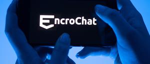 Eine Frau hält ein Smartphone mit dem Logo des Krypto-Messengerdienstes Encrochat.