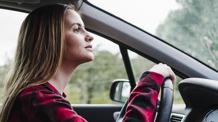 Eine junge Fahranfängerin fährt in einem Auto.