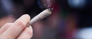 Eine Frau hält einen Joint mit Cannabis in der Hand.     