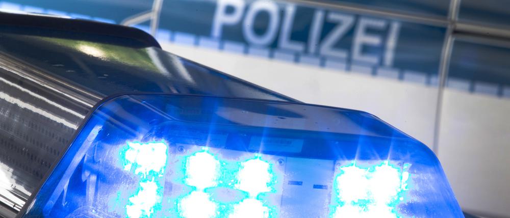 Ein Blaulicht leuchtet während eines Einsatzes auf dem Dach eines Polizeiwagens.