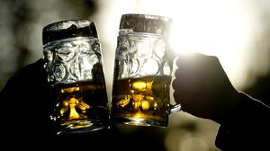 Frauen stoßen am 02.11.2014 in einem Biergarten in München (Bayern) mit zwei Bierkrügen an. 