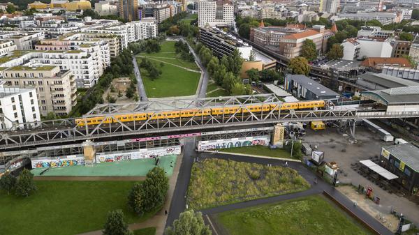 Ein Zug der U1 fährt über die U-Bahn-Brücke am Gleisdreieckpark (Luftaufnahme).