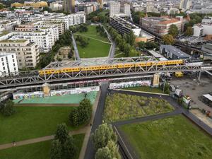Ein Zug der U1 fährt über die U-Bahn-Brücke am Gleisdreieckpark (Luftaufnahme).