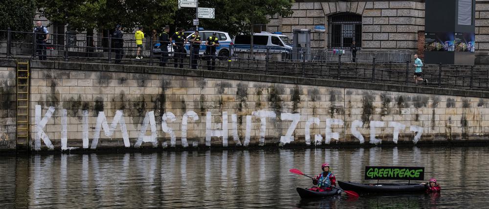 Aktivisten der Umweltschutz-Organisation Greenpeace haben auf der Kaimauer unterhalb des Reichstages das Wort „Klimaschutzgesetz“ geschrieben. 