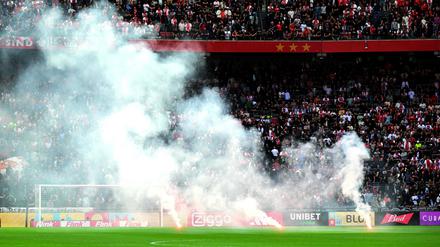 This photograph taken on September 24, 2023, shows smoke rising from fireworks thrown on the field by Ajax' supporters during the Dutch Eredivisie football match between Ajax Amsterdam and Feyenoord at the Johan Cruijff Arena in Amsterdam. (Photo by Olaf Kraak / ANP / AFP) / Netherlands OUT