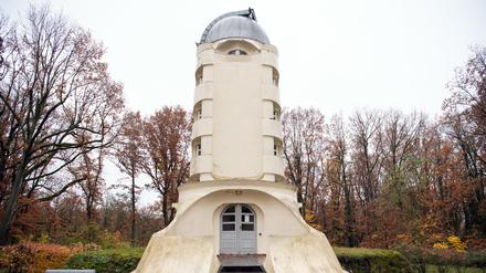Der Einsteinturm steht zwischen herbstlich belaubten Bäumen im Wissenschaftspark Albert Einstein.