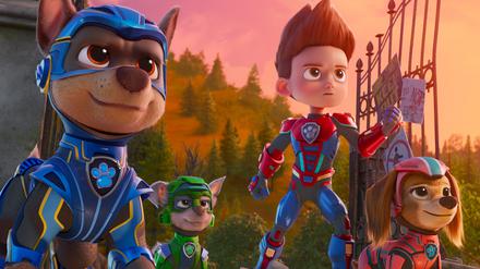 Drei der Paw-Patrol-Hunde mit Ryder, einem Jungen, der den Tieren sagt, wo es langgeht. Eine Szene aus  dem Kinofilm „The Mighty Movie“. 