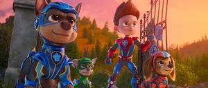 Drei der Paw-Patrol-Hunde mit Ryder, einem Jungen, der den Tieren sagt, wo es langgeht. Eine Szene aus  dem Kinofilm „The Mighty Movie“. 