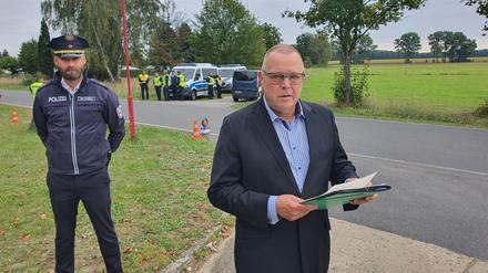Minister Michael Stübgen (CDU) vor einer Polizeikontrolle in Roggosen 