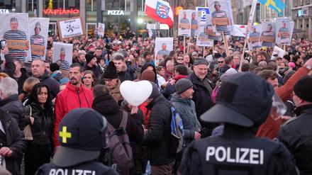 Teilnehmer einer Kundgebung von Kritikern der Coronamaßnahmen der Bundesregierung stehen auf dem Augustusplatz in Leipzig der Polizei gegenüber. 