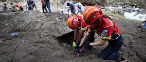 Rettungskräfte arbeiten an der Stelle, an der die Strömung eines Flusses mehrere Häuser in einer Armensiedlung in Guatemala-Stadt, weggeschwemmt hat.