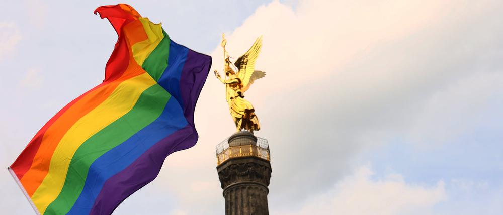 Eine Regenbogenfahne vor der Siegessäule in Berlin.