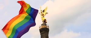 Eine Regenbogenfahne vor der Siegessäule in Berlin.