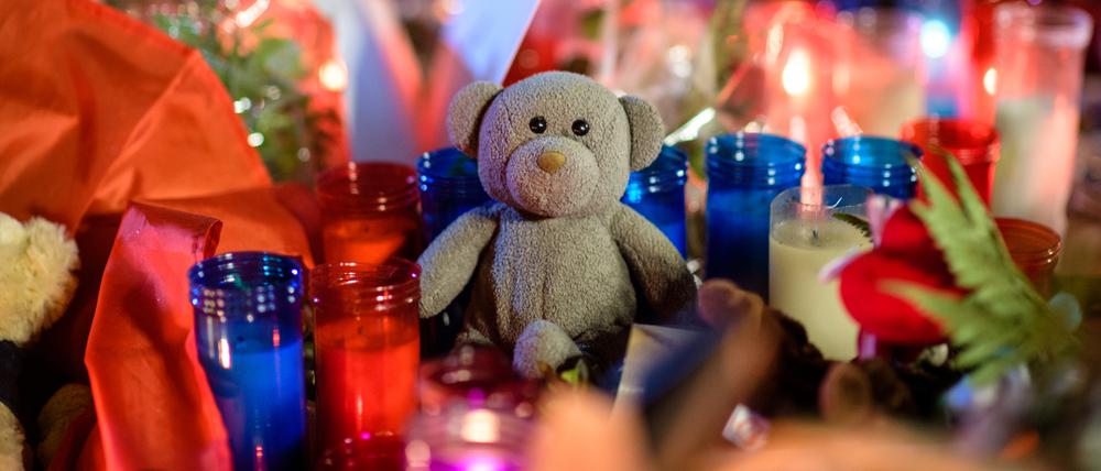 Ein Teddybär liegt am 18.08.2017 auf der Flaniermeile Las Ramblas in Barcelona (Spanien) zwischen Blumen und Kerzen.
