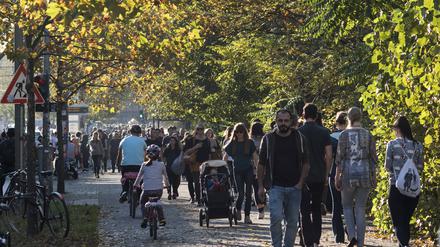 Besucher und Einheimische ziehen an einem warmen und sonnigen Herbstsonntag in den Berliner Mauerpark.