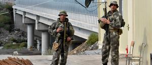 26.09.2023: Aserbaidschanische Soldaten stehen Wache, als Flüchtlinge aus Berg-Karabach den Kontrollpunkt Lachin passieren.
