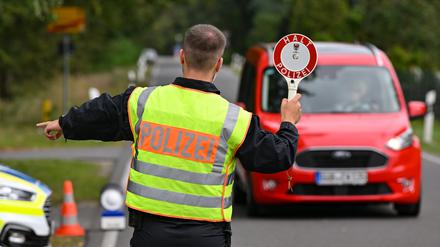 Ein Polizeibeamter stoppt ein Auto bei einer Kontrolle gegen Schleuserkriminalität. 