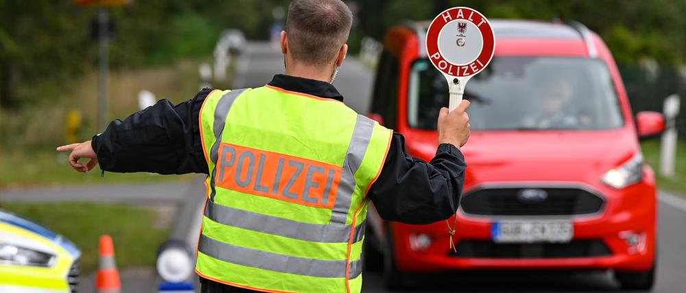 Ein Polizeibeamter stoppt ein Auto bei einer Kontrolle gegen Schleuserkriminalität.