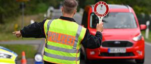 Ein Polizeibeamter stoppt ein Auto bei einer Kontrolle gegen Schleuserkriminalität. 