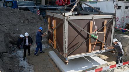 Die mittelalterliche Latrine wird in einer Transportbox an ihren endgültigen Standort auf der Fischerinsel transportiert.
