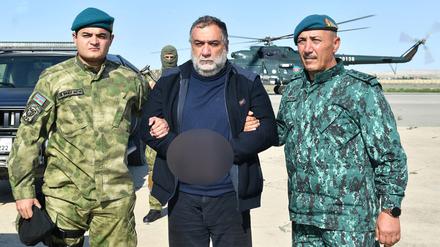 Der aserbaidschanische Grenzdienst hat am 27. September 2023 ein Foto veröffentlicht, das zeigt, wie der Separatistenführer Ruben Vardanyan von zwei aserbaidschanischen Sicherheitsbeamten festgehalten wird.