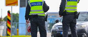 Beamte der Bundespolizei stehen am deutsch-polnischen Grenzübergang Stadtbrücke in Frankfurt (Oder) und kontrollieren Einreisende. 