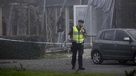 Ein Polizist steht am Ort einer starken Explosion, die sich am frühen Donnerstagmorgen in einem Wohngebiet in Storvreta außerhalb von Uppsala ereignete. Eine 25-jährige Frau kam bei der Explosion in Schweden ums Leben.