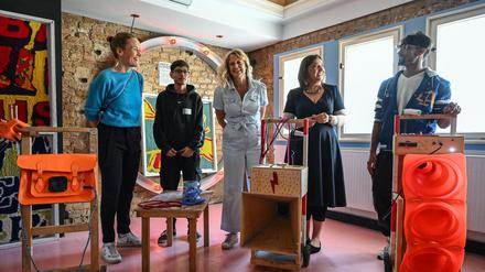 Anne Rolvering (l-r), Geschäftsführerin der Deutschen Kinder- und Jugendstiftung (DKJS), Moderatorin Barbara Schöneberger und Ekin Deligöz, Parlamentarische Staatssekretärin, testen während ihres Besuchs im Jugendprojekt auf dem Gelände „Falscher Fisch“ ein von Ali (2.v.l) und Shaheen (r) aus Afghanistan aus Alltagsgegenständen gebautes Soundsystem aus Lautsprechern und Mikrofonen. 