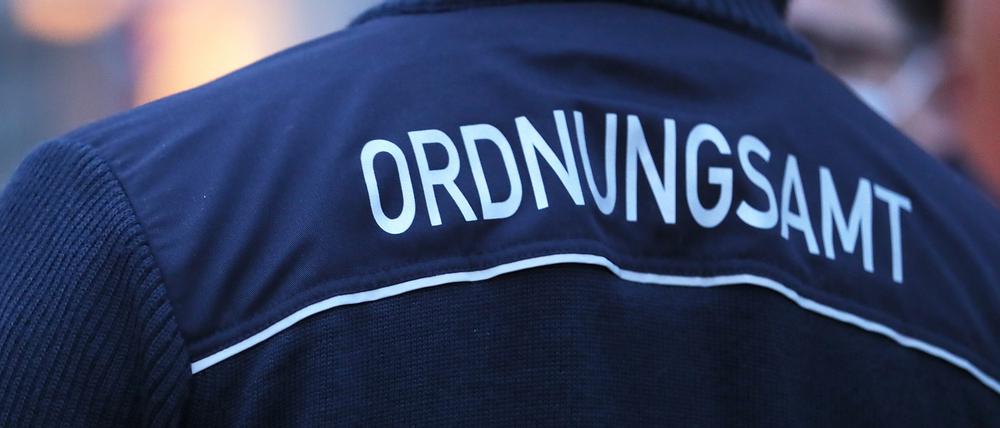 Ordnungsamt steht auf der Jacke eines Beamten. (Symbolbild)
