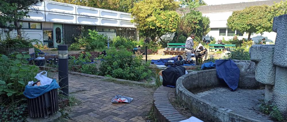 Menschen liegen auf Decken auf dem Gelände des Ankunftszentrums Asyl in Reinickendorf.