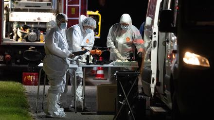 28.09.2023, Hessen, Bad Emstal: Mitarbeiter der Spurensicherung stehen an ihren Einsatzfahrzeugen.