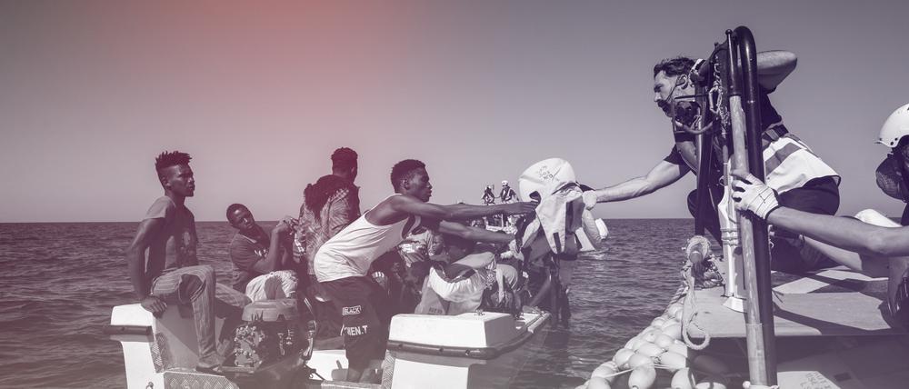 Migranten vor der Küste Libyens erhalten Hilfe durch die Besatzung eines Seenotrettungsschiffes.