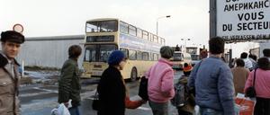 Ein BVG-Bus fährt von Osten durch eine Öffnung in der Berliner Mauer.